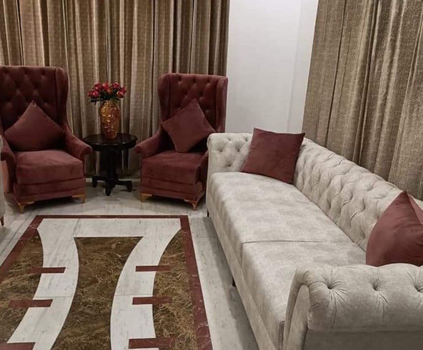 Cream tufted sofa and two maroon wing chairs